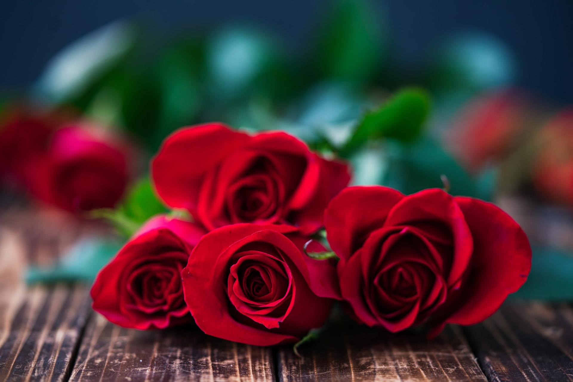 A small posy of roses resting on a wooden table