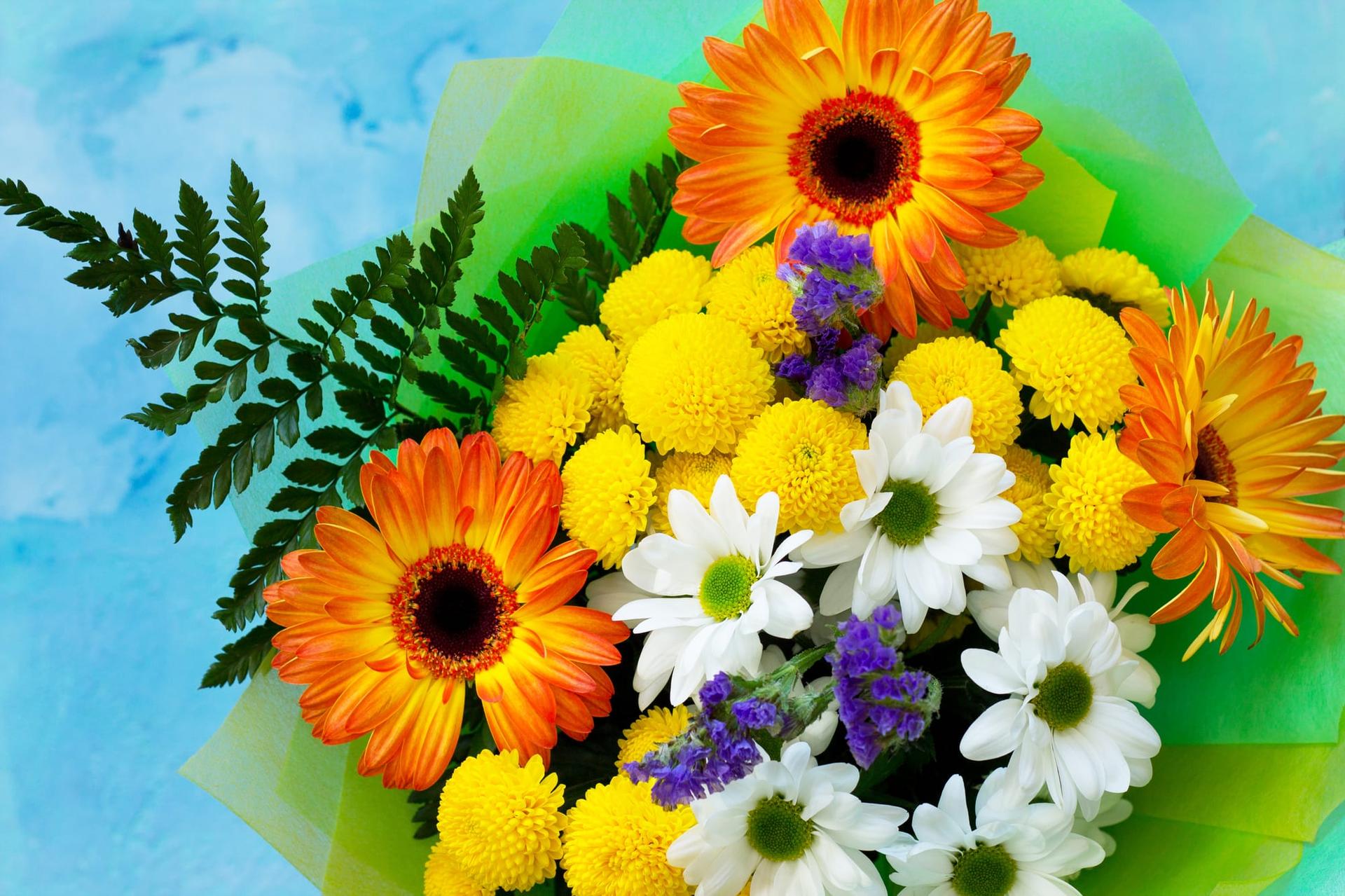 A cheerful basket bouquet of bright gerberas and chrysanthemums