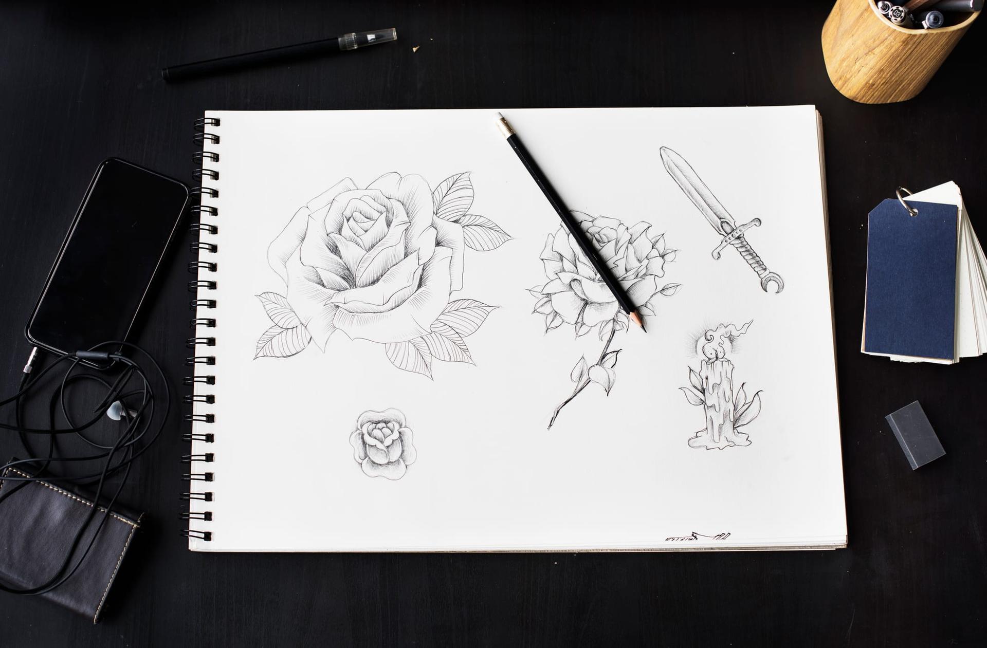 A botanical rose drawing in progress on paper