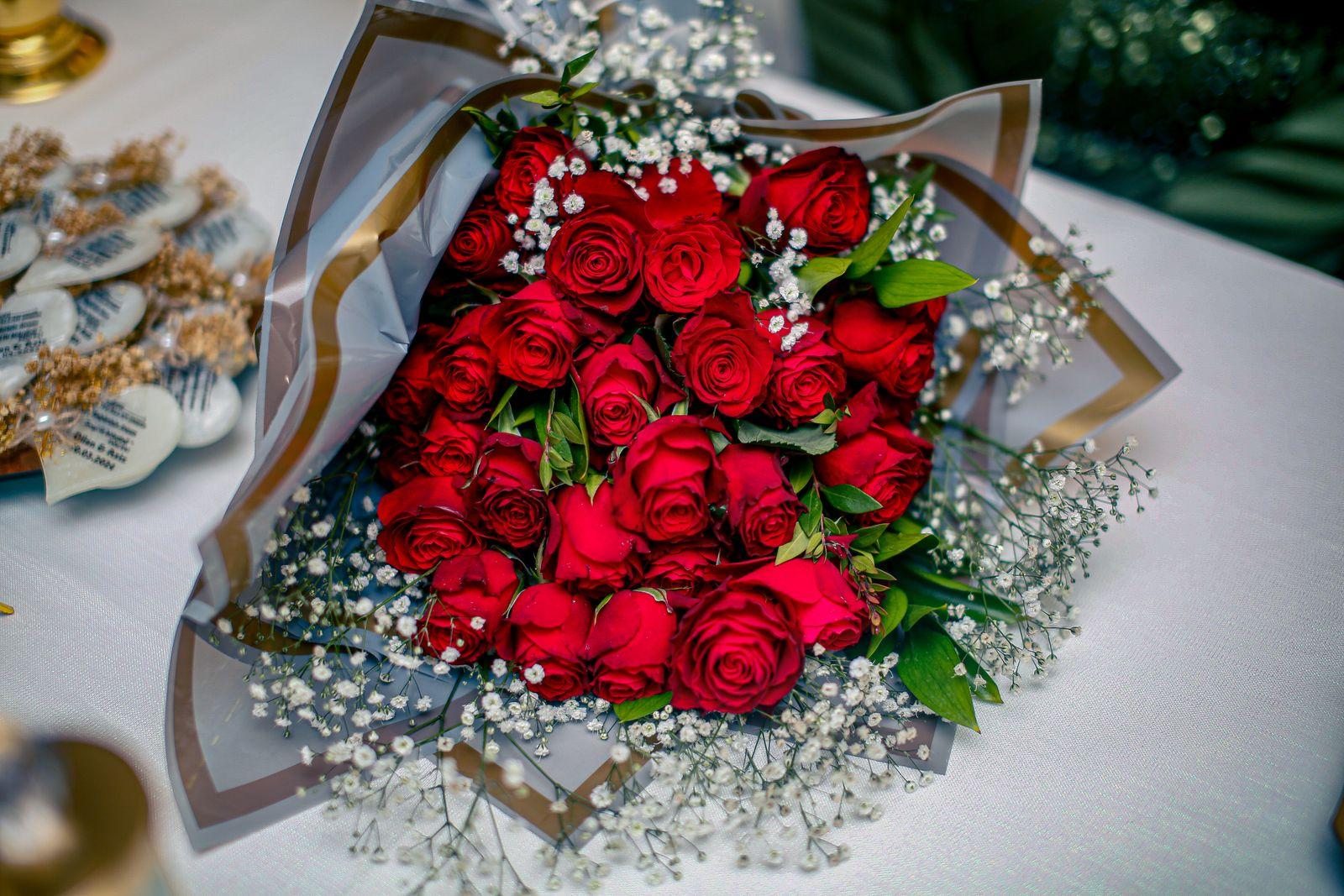 Wrapped bouquet of red roses with white baby's breath