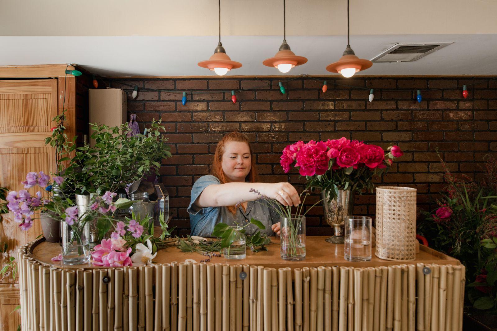 A florist arranging a bouquet at a workbench