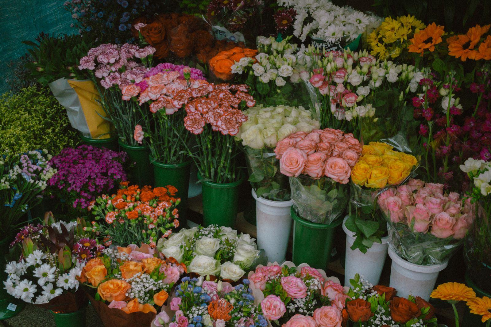 Buckets of fresh flowers for sale at a flower stall