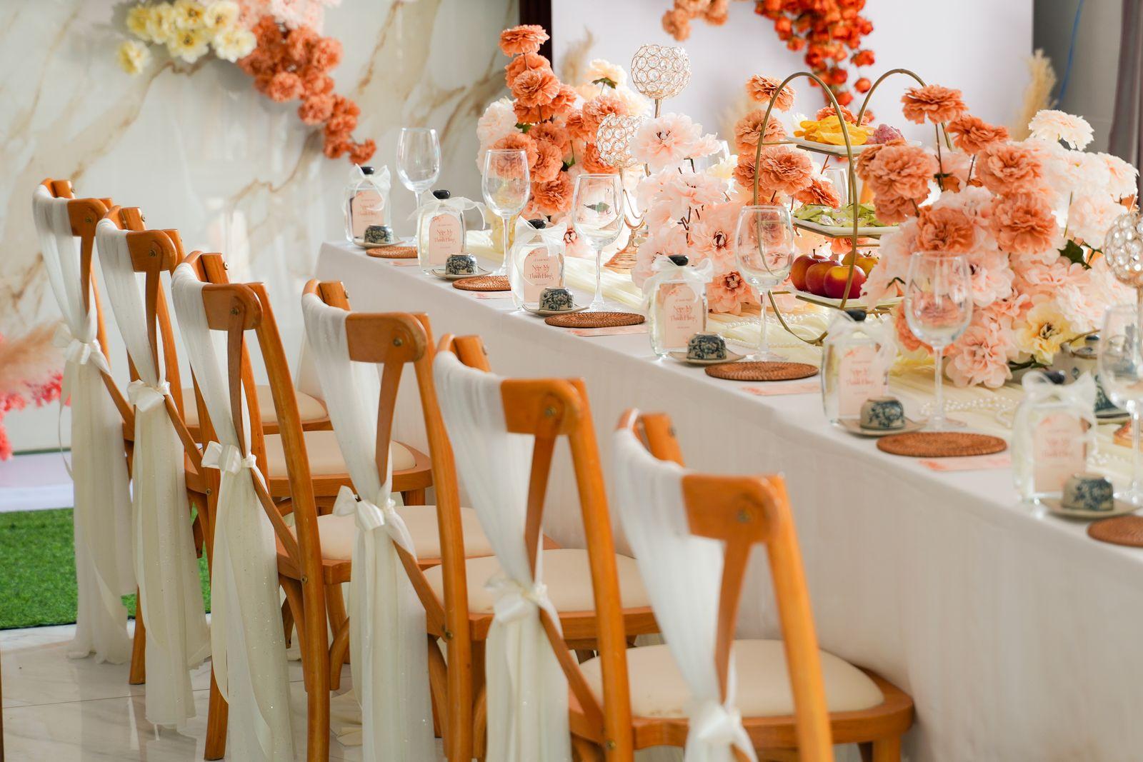 A wedding reception table set with a low floral centrepiece