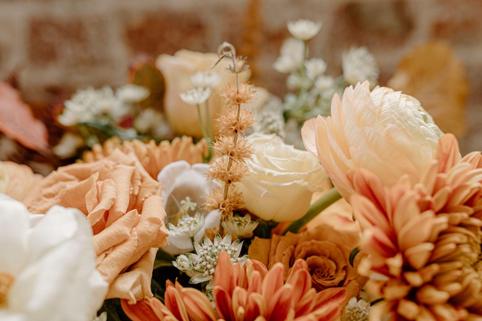 Close-up of an autumn bouquet with terracotta and peach roses, dahlias and cream blooms