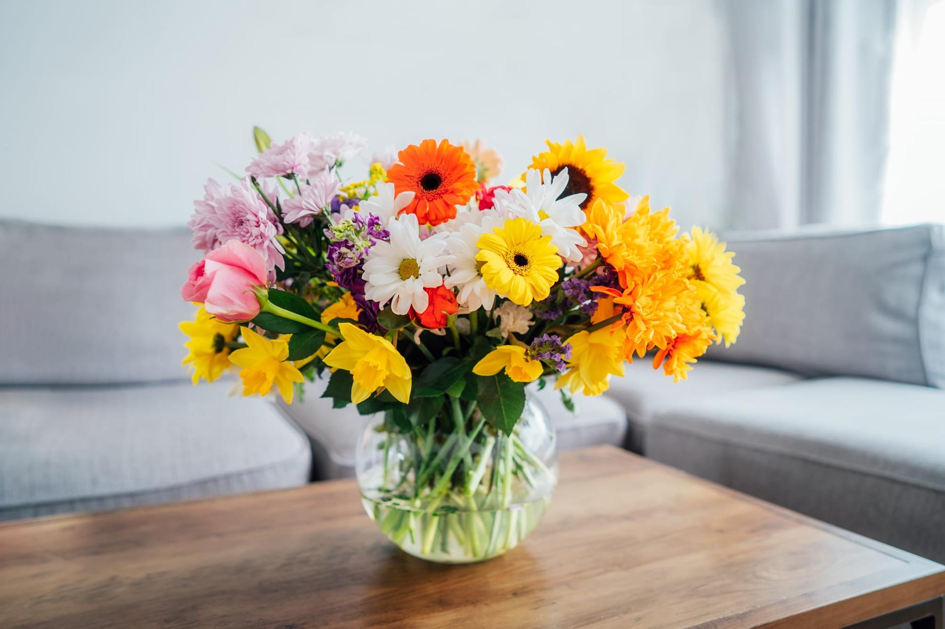 A vase of long-lasting mixed cut flowers on a coffee table